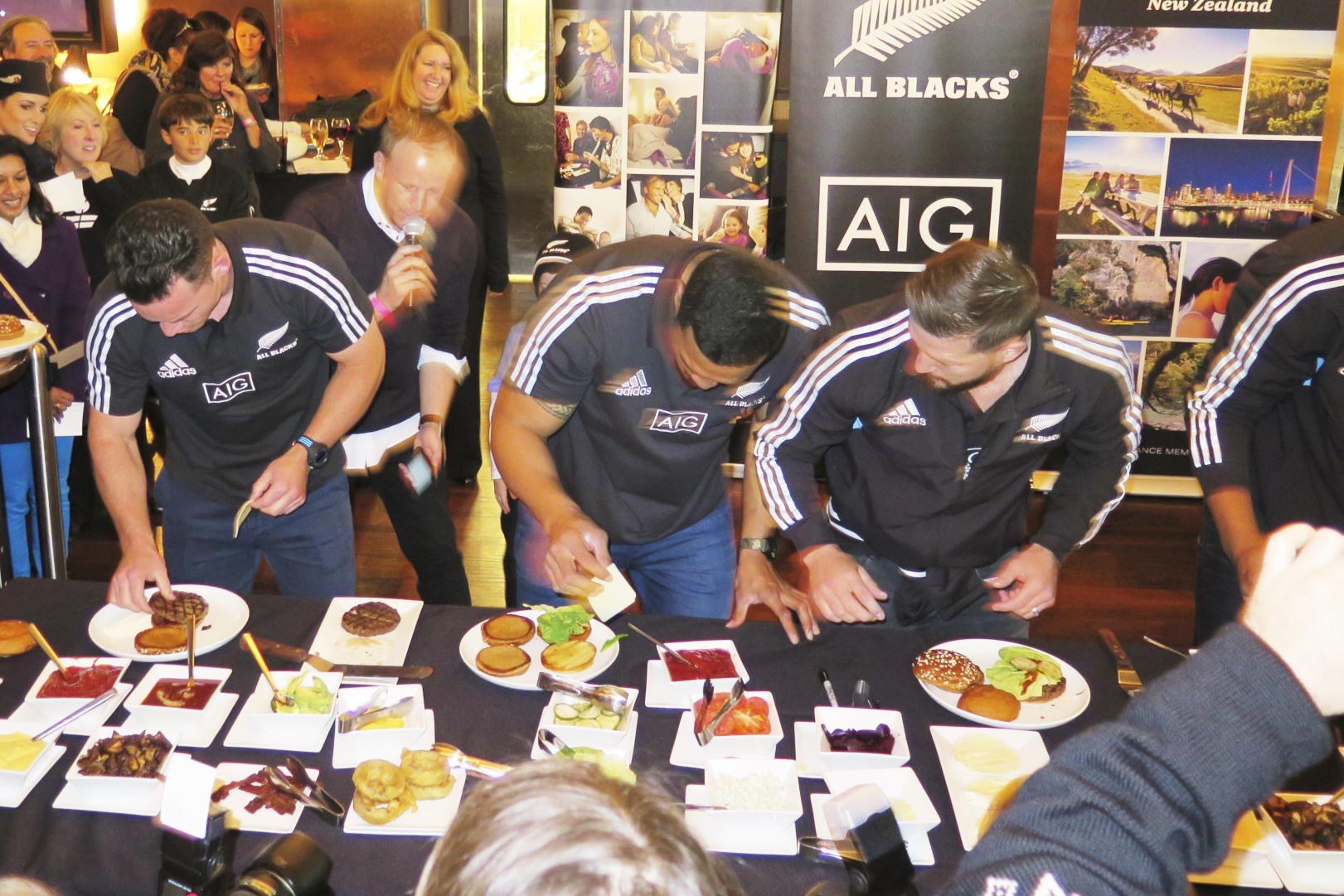 Several All Blacks partaking in a burger making contest