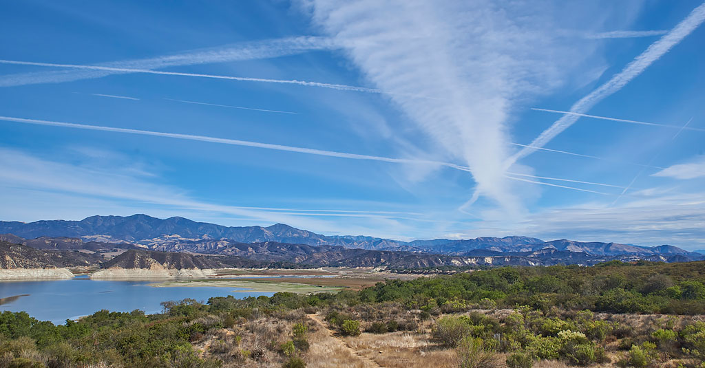 Vapour trails crisscross the sky above Lake Cachuma